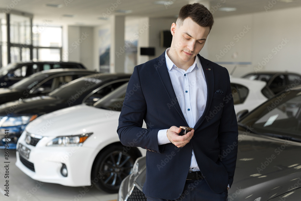 Handsome man choosing a car in a show room Handsome man choosing a car in a show room