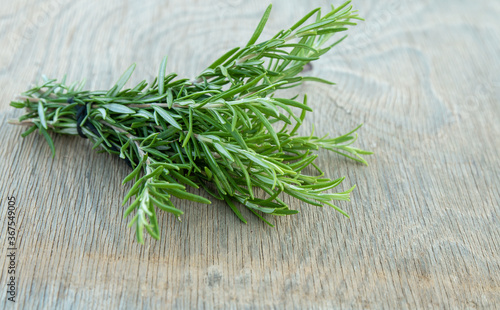 Beautiful Greek wild rosemary on natural wooden background. Copy space for text. Space for you product.