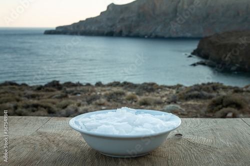 Flower of Greek sea salt crystals, south Crete. Natural traditional Fleur de sel from Crete. Sea salt flakes on wooden bakcground.