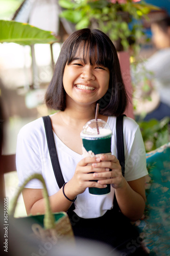 asian teenager happiness face with cool drink bottle in hand