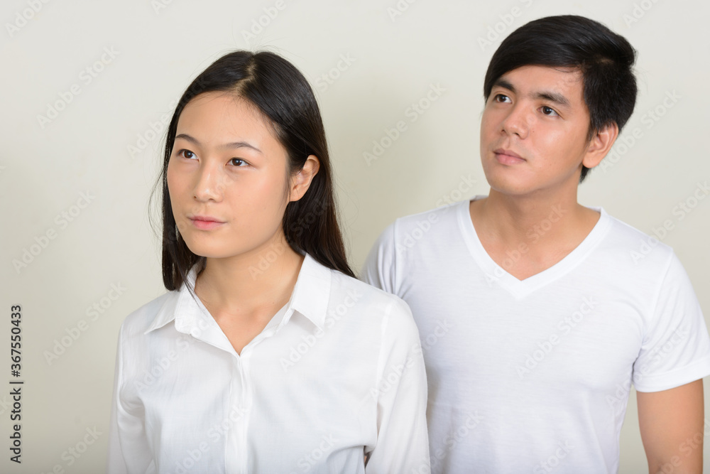 Portrait of young Asian couple together against white background Portrait of young Asian couple together against white background
