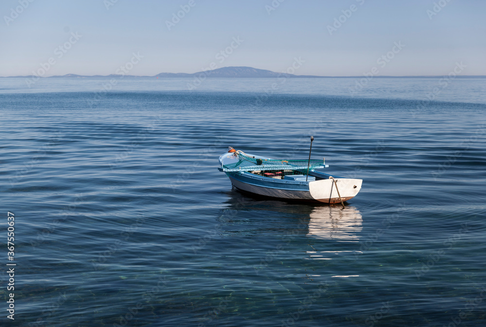 Small fishing boat on the blue sea and blue sky,peaceful and lonely,Novalja,Pag,Croatia