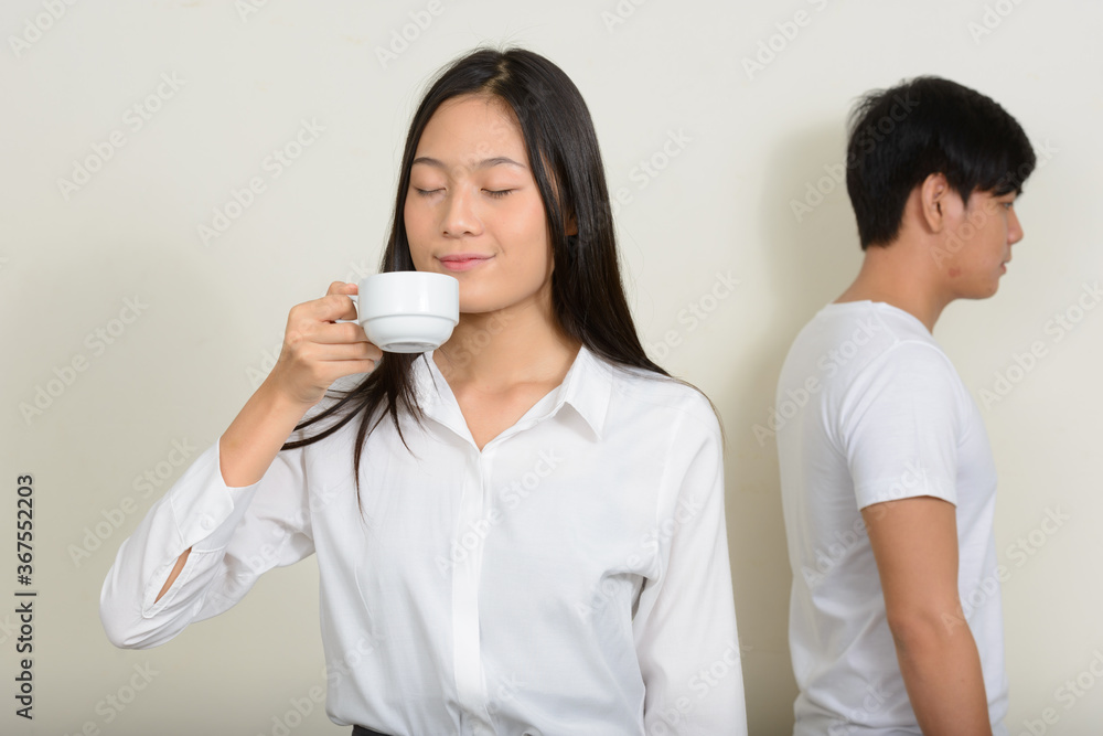Portrait of young Asian couple together against white background Portrait of young Asian couple together against white background