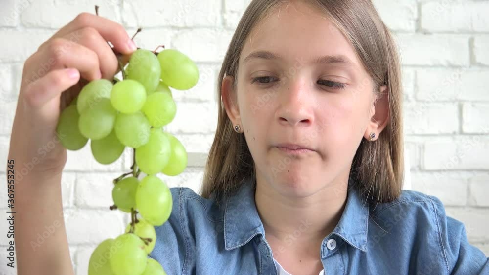 Kid Eating Grapes, Child Eats Fruits, Young Girl at Breakfast in Kitchen Kid Eating Grapes, Child Eats Fruits, Young Girl at Breakfast in Kitchen