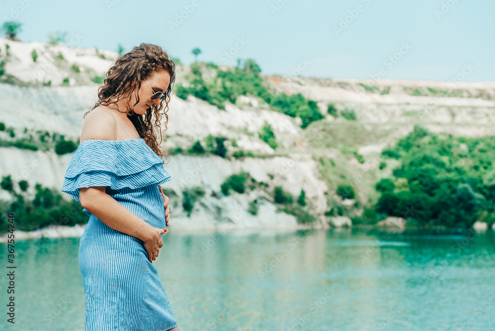 Beautiful pregnant woman standing on the beach Beautiful pregnant woman standing on the beach