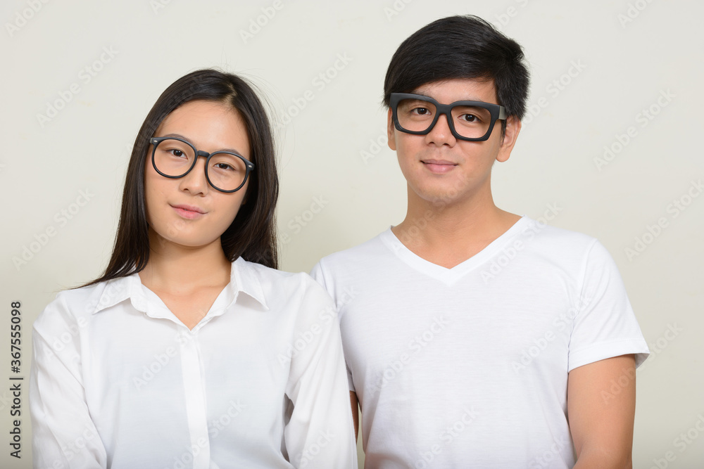 Portrait of young Asian couple together against white background Portrait of young Asian couple together against white background