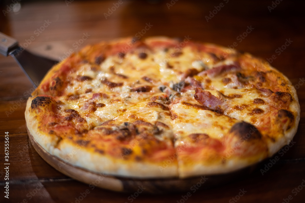Close up pizza on woodden plate.