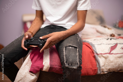 Cropped shot of teenager using remote control while playing games