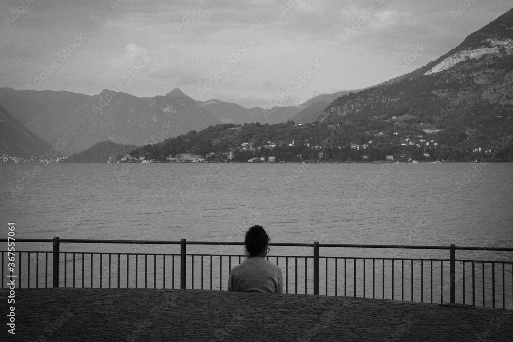 Admires the lake.
Black and white photo with lady in relax that admire the landscape lake.