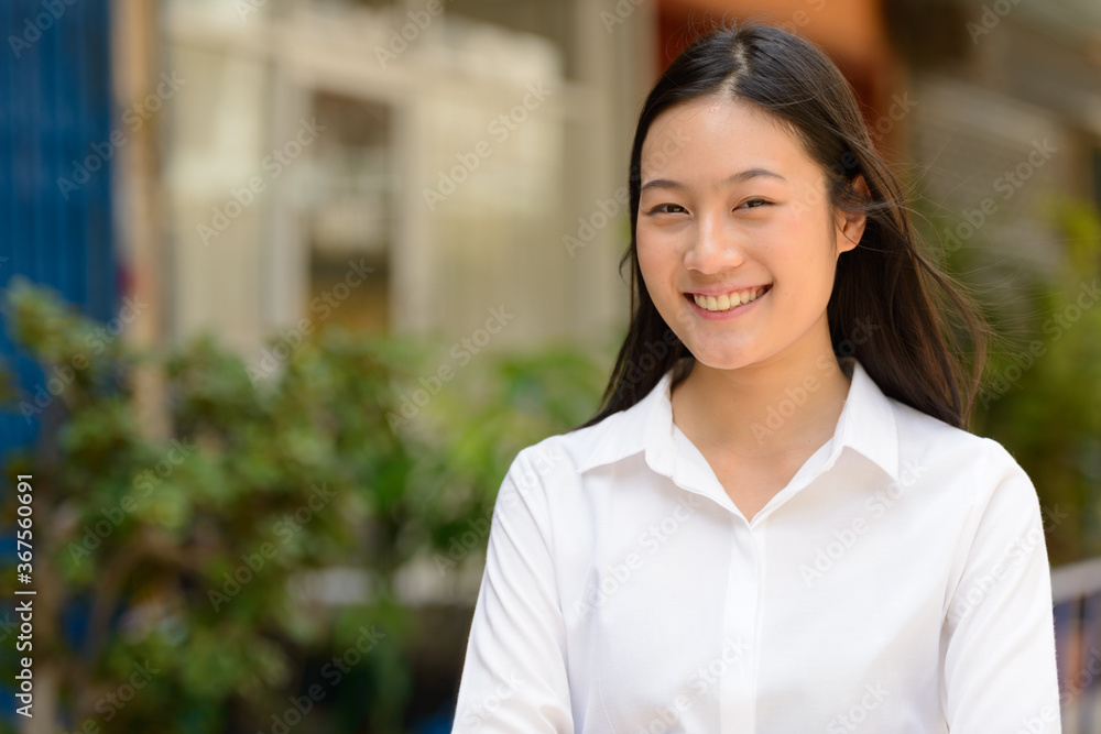 Portrait of young beautiful Asian businesswoman outdoors