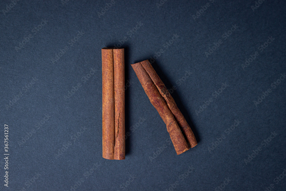 Cinnamon on a black background. Two cinnamon sticks, one next to the other. Photo from above Cinnamon on a black background. Two cinnamon sticks, one next to the other. Photo from above