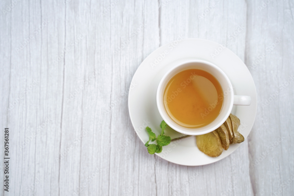 Top view of Cup of hot ginger tea with lemon and mint on wooden table. the concept of natural medicine. Top view of Cup of hot ginger tea with lemon and mint on wooden table. the concept of natural medicine.