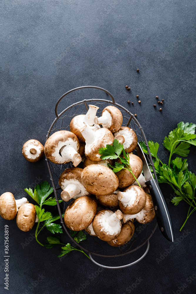 Raw mushrooms champignons on black background, cooking fresh champignons. Raw mushrooms champignons on black background, cooking fresh champignons.