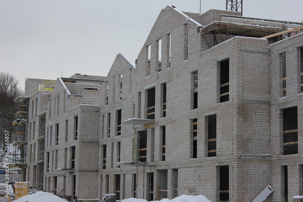 Construction of residential building in the city at winter time 