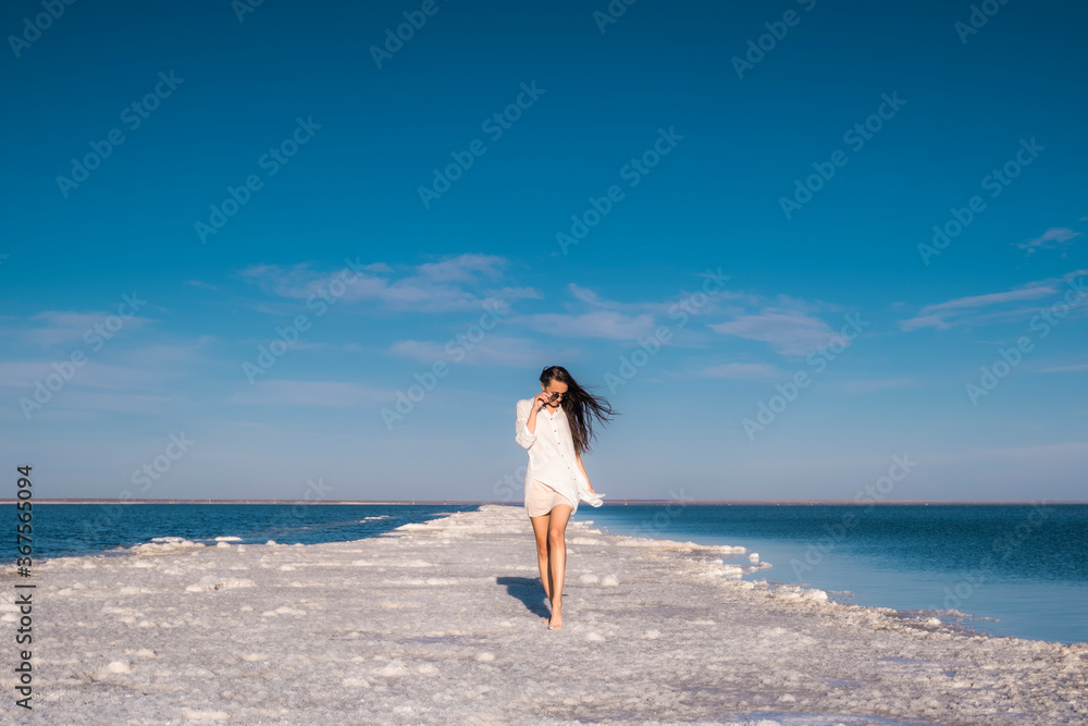 Beautiful girl in a beach dress by the sea. Woman on a salt lake. Beautiful girl in a beach dress by the sea. Woman on a salt lake.