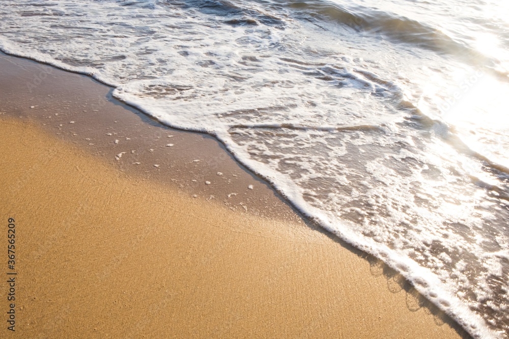 Foamed water on the sandy beach during the daytime Foamed water on the sandy beach during the daytime