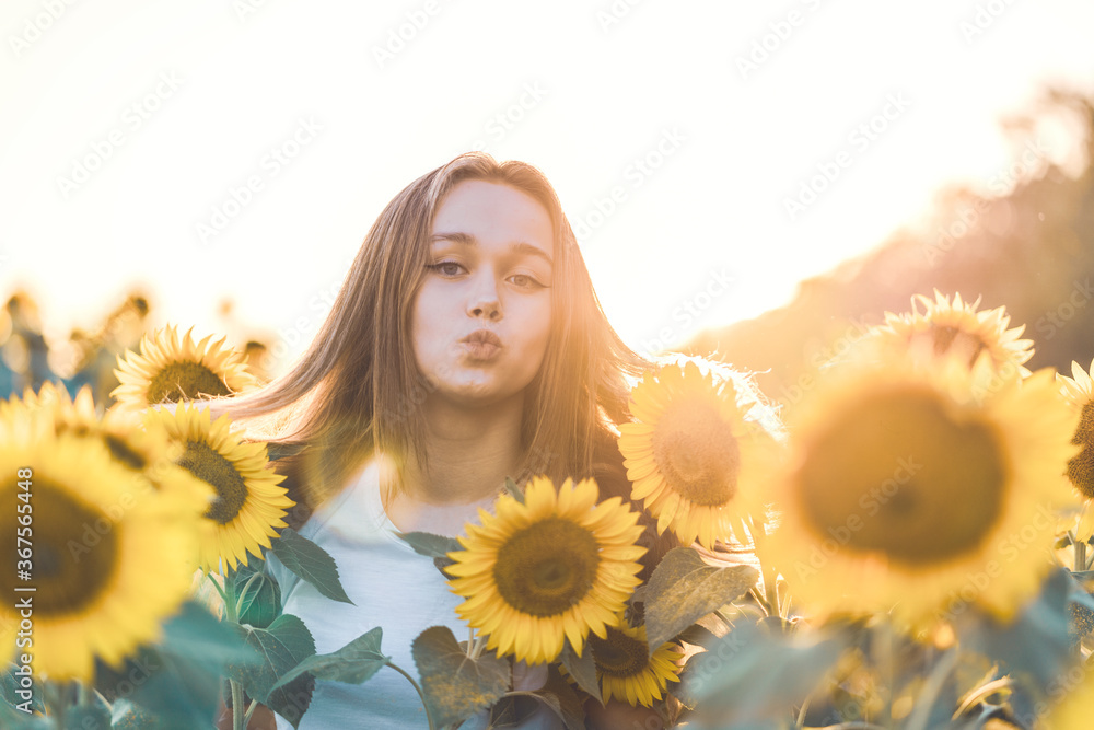 © Juliaap - Young beautiful woman smiling and having fun in a sunflower field on a beautiful summer day.