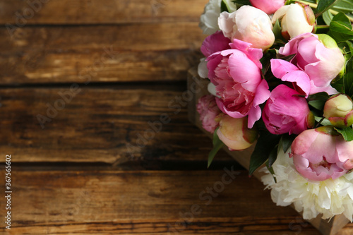 Bouquet of beautiful peonies on wooden table. Space for text © New Africa
