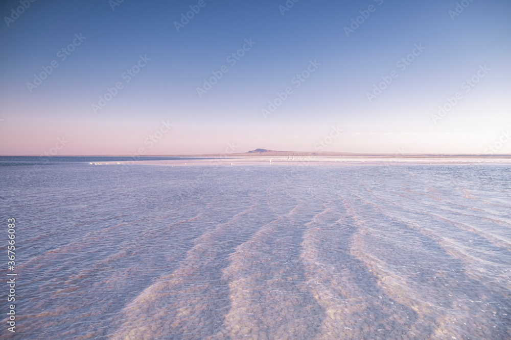 Nature beautiful sunset on the lake. Salt lake in the Astrakhan region. Clear water. Pink sunset landscape. Nature beautiful sunset on the lake. Salt lake in the Astrakhan region. Clear water. Pink sunset landscape.