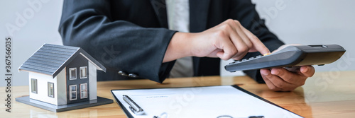 Real estate agent working sign agreement document contract for house insurance approving purchases for client with house model and key on table