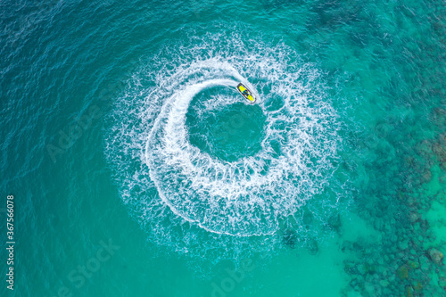 Fototapeta Naklejka Na Ścianę i Meble -  People are playing a jet ski in the sea. Aerial view and top view. Amazing nature background.