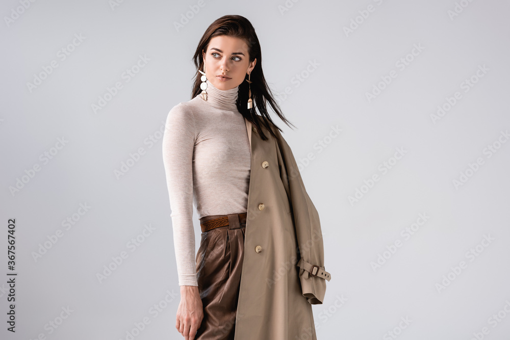 beautiful, elegant girl holding trench coat and looking away isolated on grey - obrazy, fototapety, plakaty 