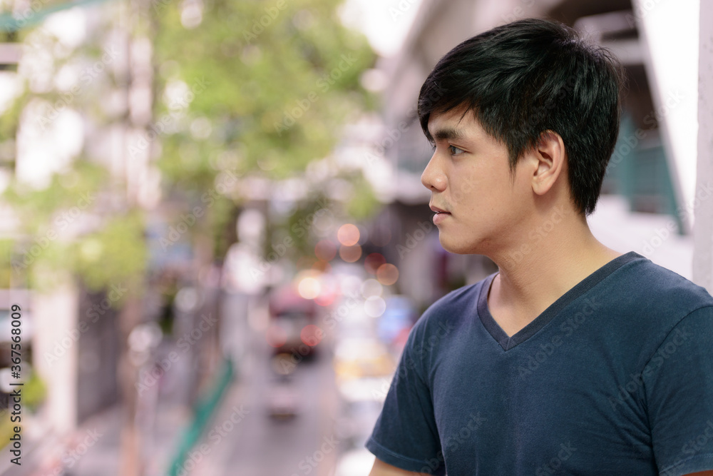 Portrait of young handsome Asian man in the city Portrait of young handsome Asian man in the city