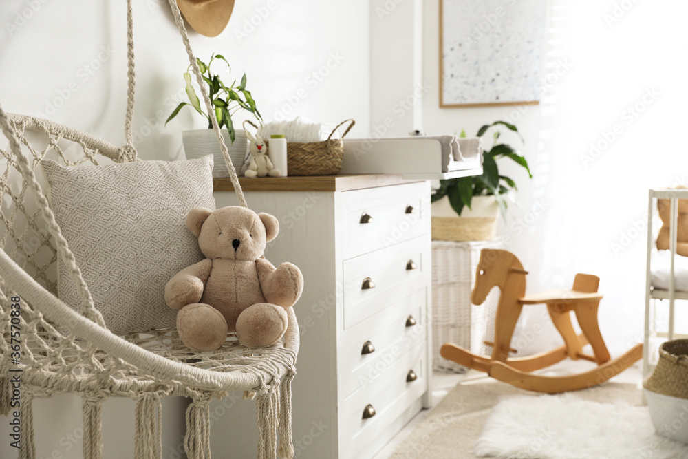 Stylish swing and changing table in baby room. Interior design - obrazy, fototapety, plakaty 