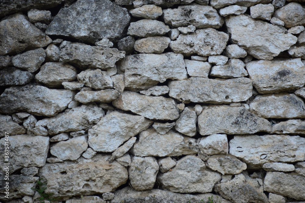 wall texture of limestone stones of various shapes and sizes. stones stacked into a wall