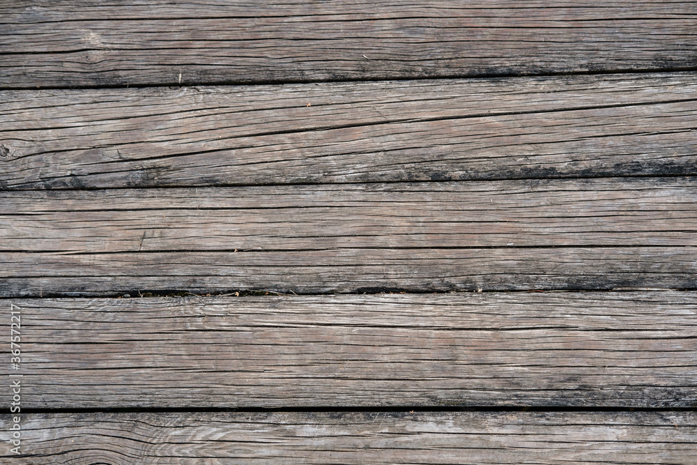The background is made of old thin wooden logs of a grayish shade, with a lot of longitudinal cracks. The background is made of old thin wooden logs of a grayish shade, with a lot of longitudinal cracks.
