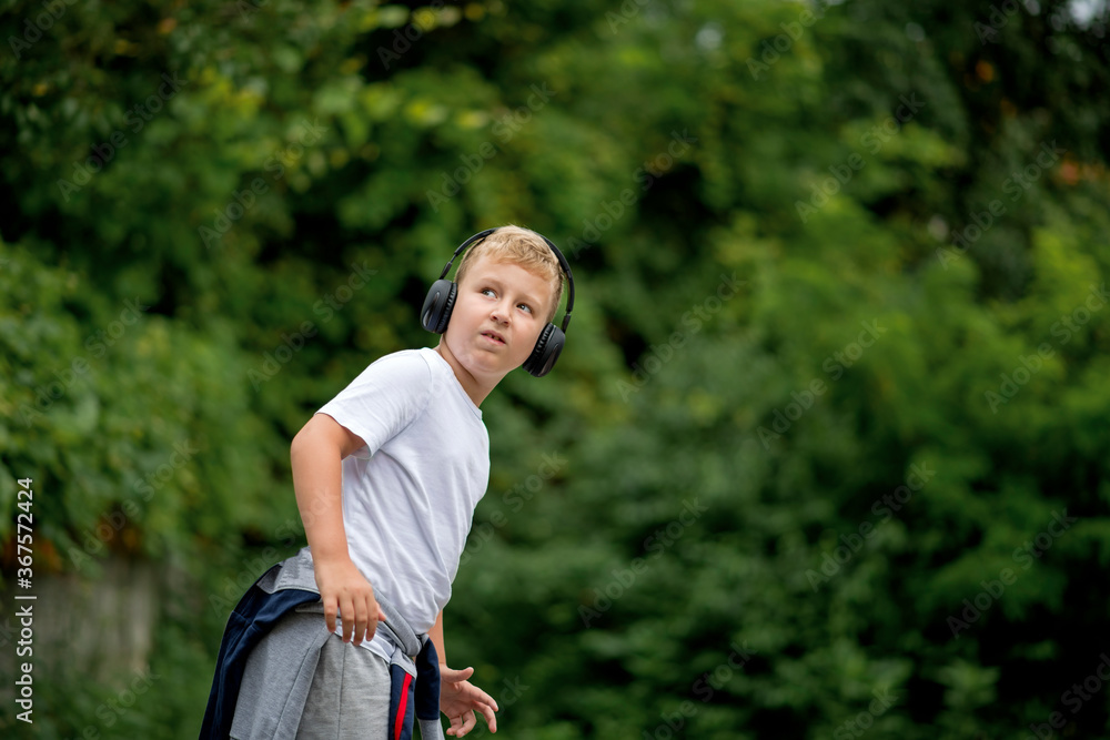 Fototapeta premium Caucasian blond boy listening music from his smart phone