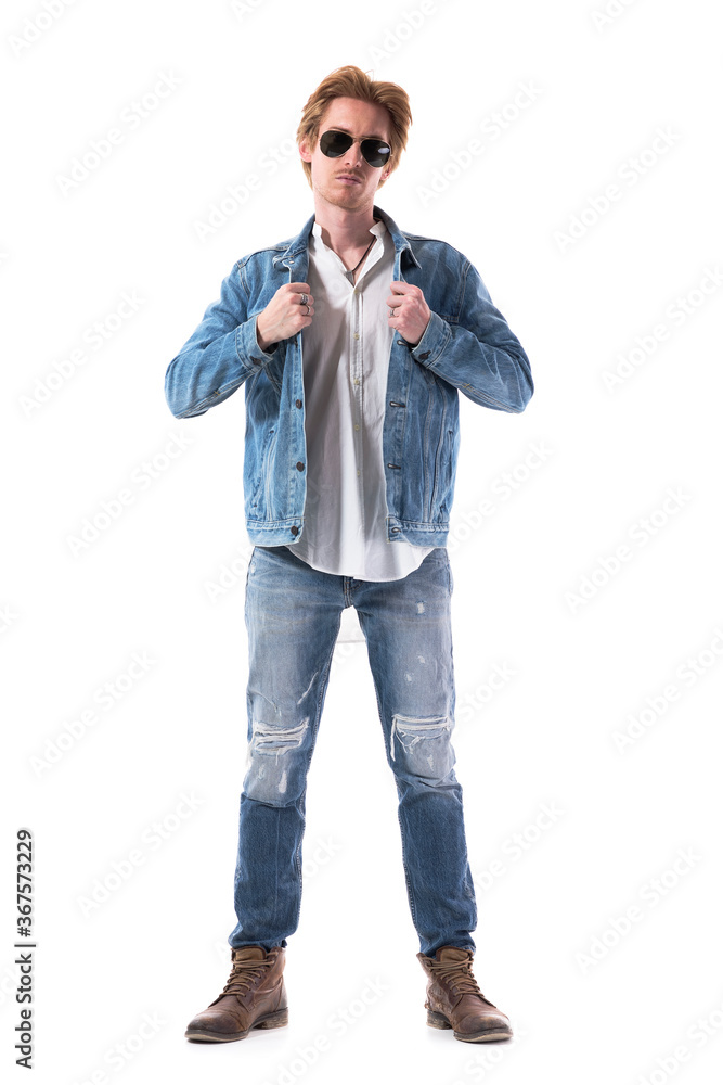 Stylish young handsome man getting dressed put on denim jacket looking at camera. Full body length isolated on white background. Stylish young handsome man getting dressed put on denim jacket looking at camera. Full body length isolated on white background.
