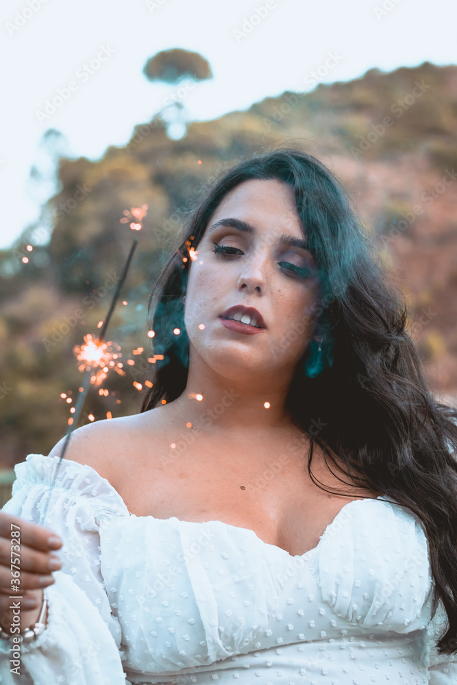 Pretty brunette girl with a sparkler in her hand Pretty brunette girl with a sparkler in her hand