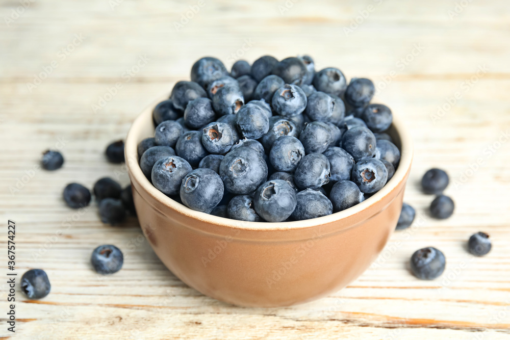 Tasty ripe blueberries in bowl on white wooden table Tasty ripe blueberries in bowl on white wooden table