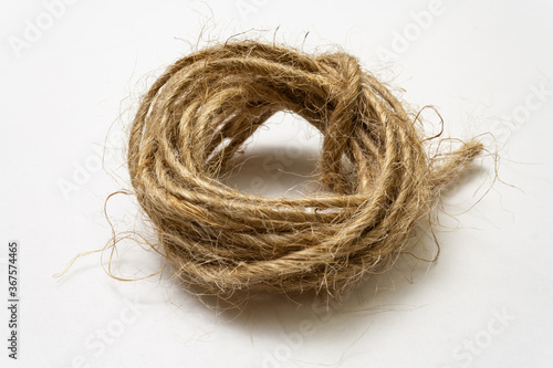 Jute twine isolated on white background. hank of twine close-up. jute rope for packing and decoration. skein of natural jute twine macroshot. Linen rough threads. raw material for industrial