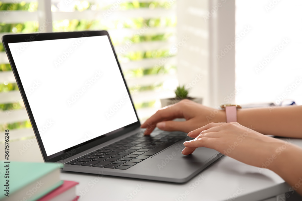 Fototapeta premium Woman working with modern laptop at white table, closeup