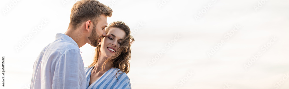 panoramic shot of happy girl smiling near cheerful boyfriend outside panoramic shot of happy girl smiling near cheerful boyfriend outside