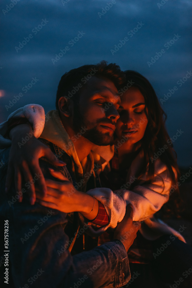 attractive woman hugging handsome man at night