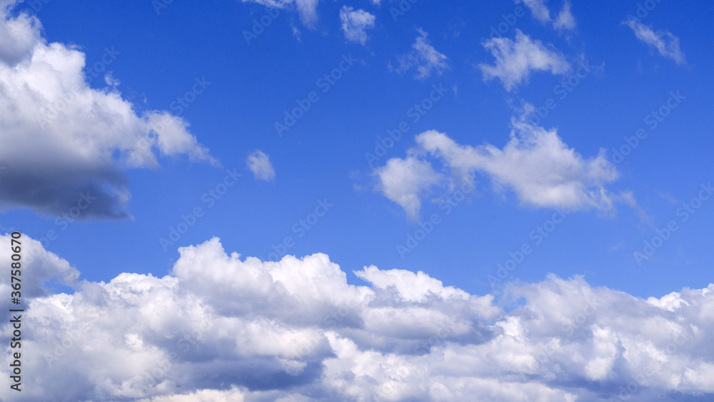 Fototapeta premium White fluffy clouds in the vast blue sky. Abstract nature background.