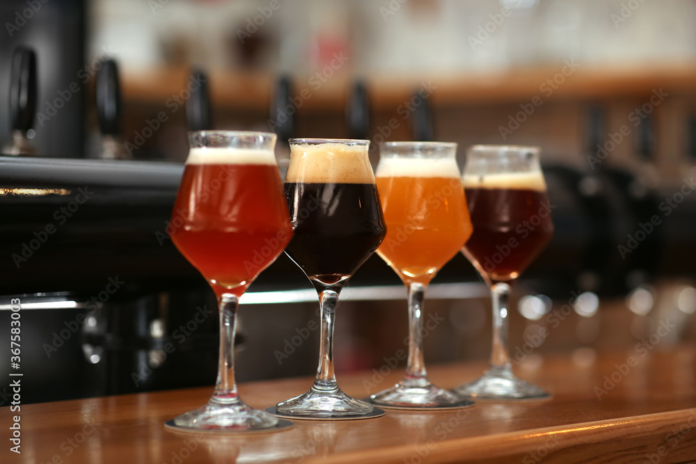 Different beers in glasses on bar counter Different beers in glasses on bar counter