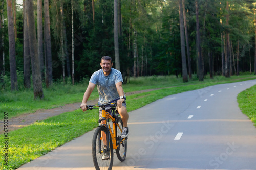 Fototapeta Naklejka Na Ścianę i Meble -  Strong man on a bike in the park