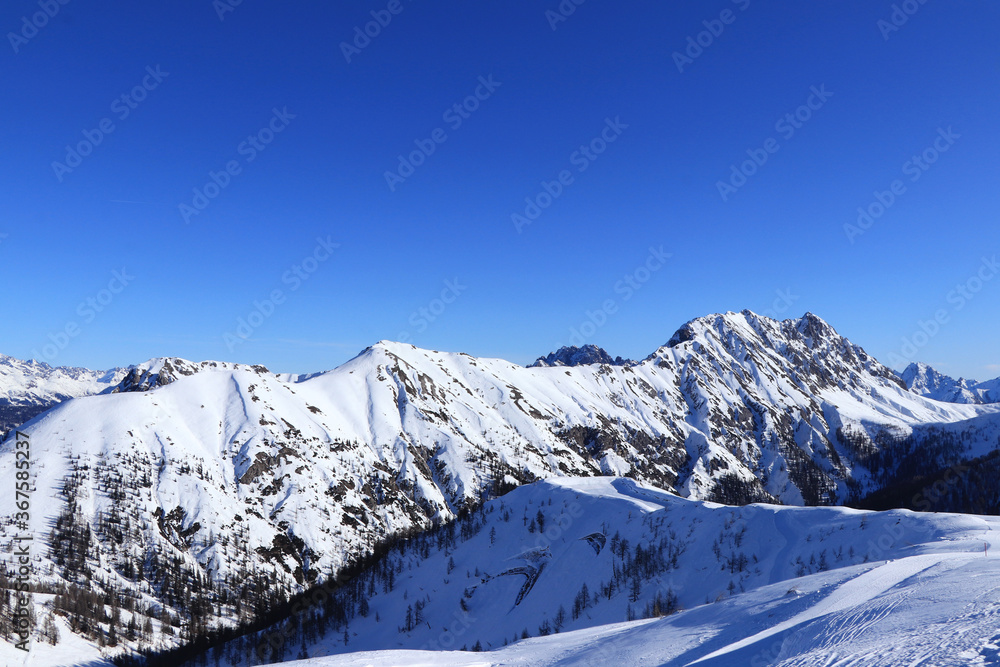 Eggenkofel is dominant of Gaital alps in tyrol, west Austria. Beautiful scenery with snow mountain peaks and blue sky. Skiing in Obertilliach Ski Resort