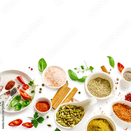 Different indian spices in a bowls and herbs on white background. Top view of indian spices with copy space.