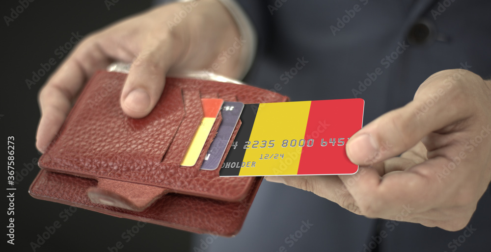 Obraz premium Businessman pulls credit card with flag of Belgium out of his wallet, fictional card number