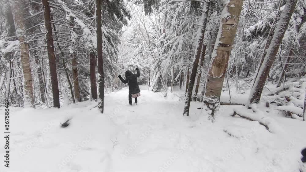 Two people hiking through a steep snow covered mountain forest Two people hiking through a steep snow covered mountain forest