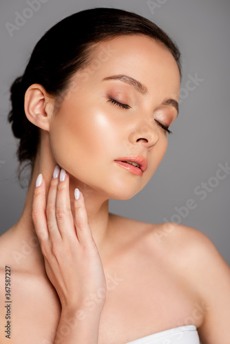 portrait of beautiful woman with shiny makeup and closed eyes isolated on grey