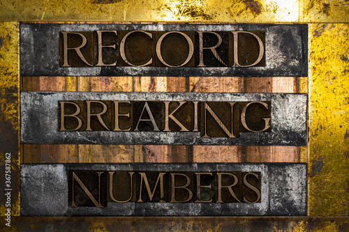 Record Breaking Numbers text formed with real authentic typeset letters on vintage textured silver grunge copper and gold background photo