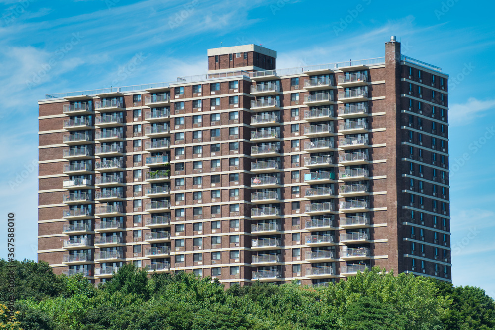apartment building surrounded by trees on a sunny day apartment building surrounded by trees on a sunny day