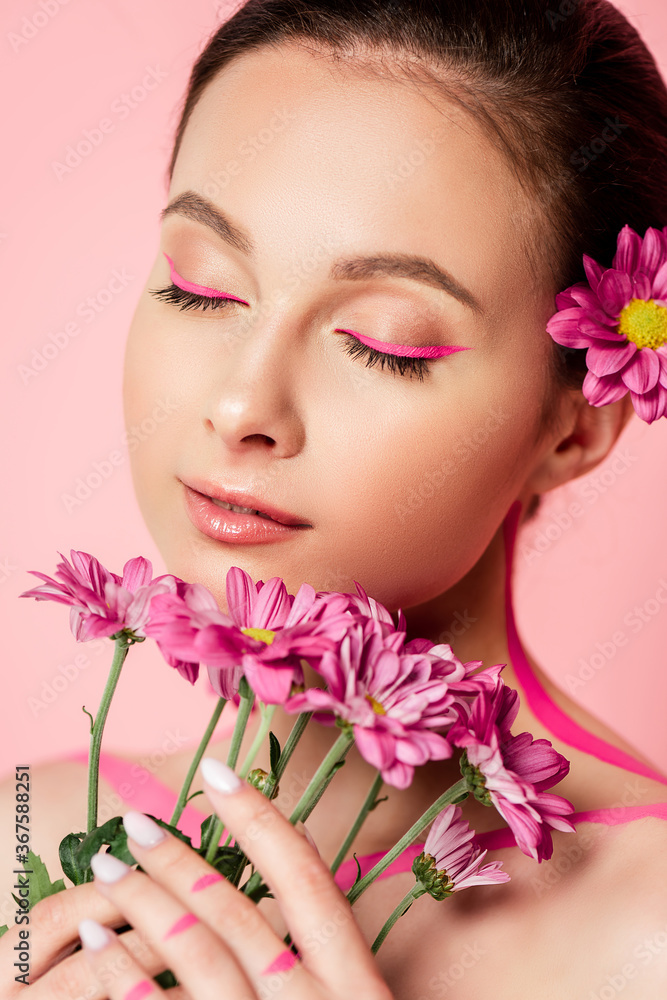 naked beautiful woman with closed eyes, pink lines on body and flower in hair holding bouquet isolated on pink naked beautiful woman with closed eyes, pink lines on body and flower in hair holding bouquet isolated on pink