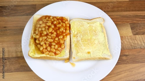 Pouring Beans On Toast With A Large Metal Ladle
